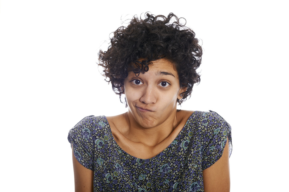 Portrait of confused and uncertain hispanic woman isolated on white background and looking at camera